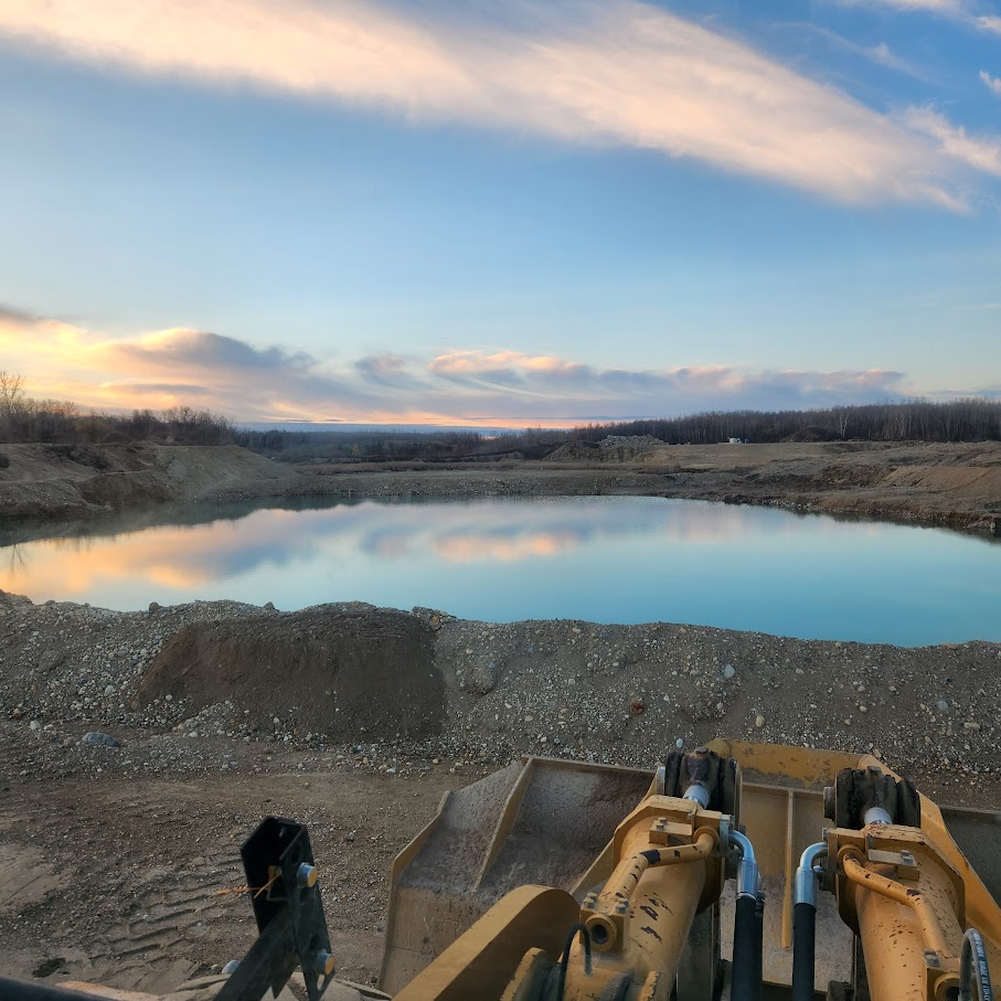 Front-end loader on a job site at sunset